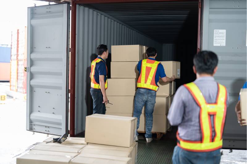 Workers are loading Cartoon Box in the Container
