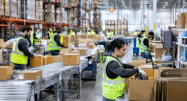 Warehouse staff picking and packing a high volume of orders on a conveyor line